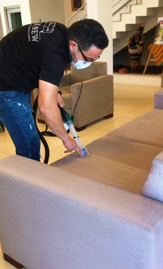 Profissional da Sofá New durante atendimento de limpeza de estofado em residência